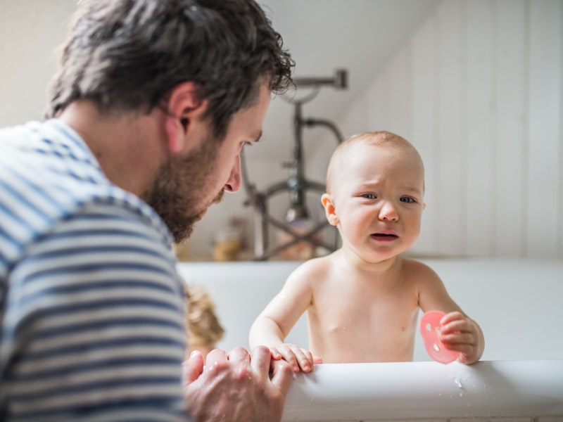 Mutter badet ihr Baby behutsam